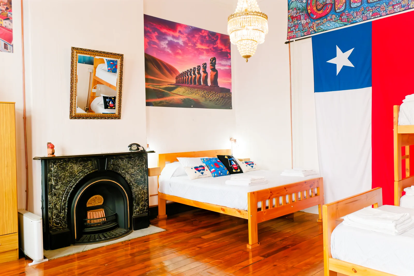 Cama junto a la bandera chilena y la chimenea en la habitación Chile de CasaFran